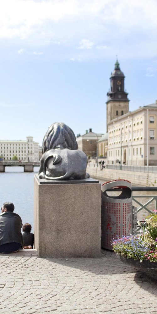 Seated passenger looking out tram window at Gothenburg scenery